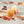 Load image into Gallery viewer, Close-up of a short glass of a non-alcoholic mixed drink with an apple slice garnish. Cinnamon sticks, star anise, and fall leaves are scattered around the glass.