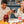Load image into Gallery viewer, Two laughing women sit at a table, clinking together glasses of non-alcoholic mixed drinks. A charcuterie board and a carafe containing a non-alcoholic cocktail rest on the table.